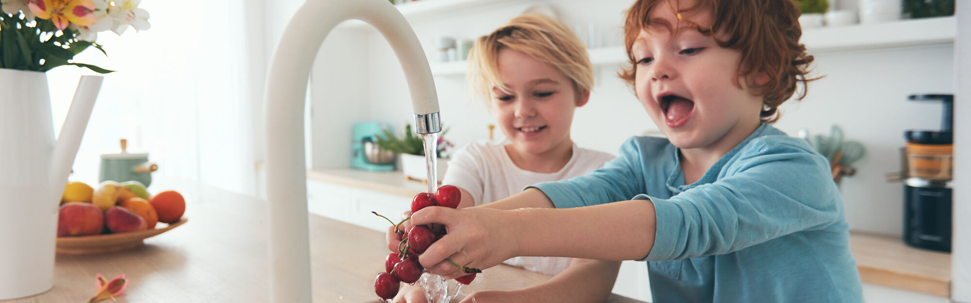 kids washing grapes at kitchen sink