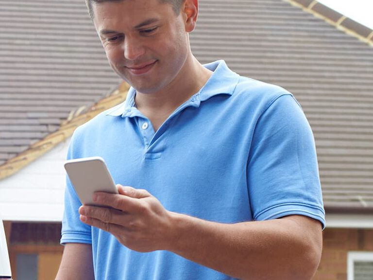 Contractor Rewards - man smiling while looking at phone Contractor Rewards - man smiling while looking at phone