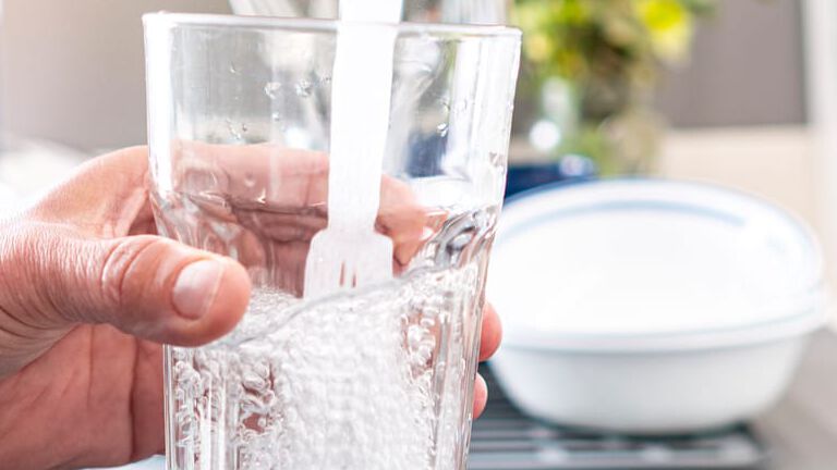 glass of water filling under faucet glass of water filling under faucet